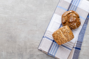 Gold rustic crusty loaves of bread and buns on wooden background. Still life captured from above top view, flat lay.