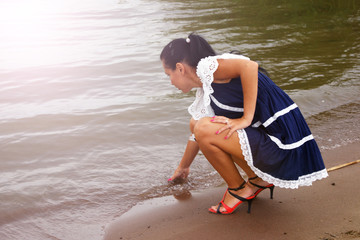 Girl on the beach touching the water