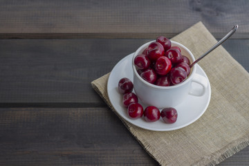 Fresh organic ripe sweet cherry in a white ceramic mug
