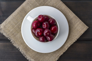Fresh organic ripe sweet cherry in a white ceramic mug