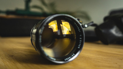 Old, vintage, retro style, isolated camera lens on wooden table - close up