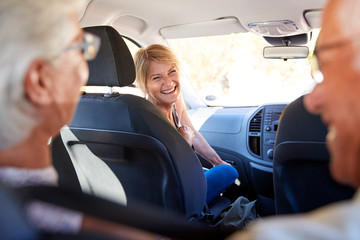 Group Of Senior Friends Sitting In Car Driving To Vacation