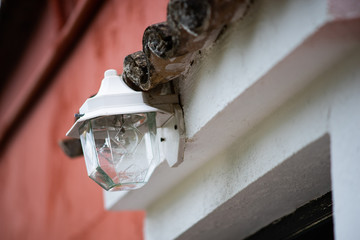Traditional vintage wall lantern metal electric light above the door of a old house entrance in the afternoon day