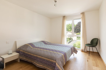 Modern bedroom with bed and velvet chair