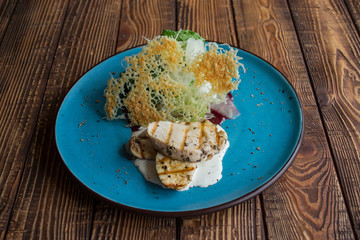 The hot salad with meat on a wooden background.