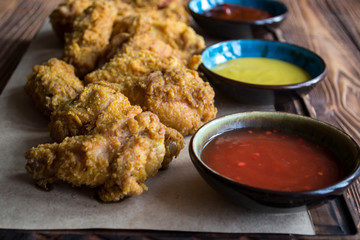 Fried chicken with sauce on a wooden table.