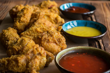 Fried chicken with sauce on a wooden table.