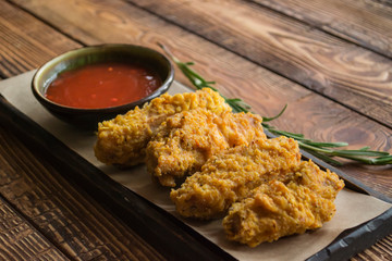 Fried chicken with sauce on a wooden table.