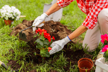 Woman wearing white flowers digging ground after planting flowers