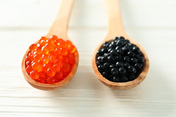 Spoons with caviar on white table, space for text