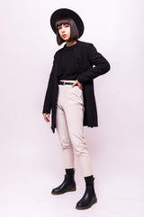Style. Fashion full portrait of a young woman in black clothing isolated on white background
