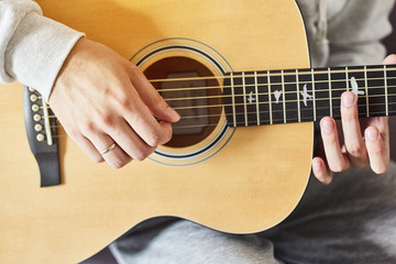 Cropped shot of man practicing in playing acoustic guitar