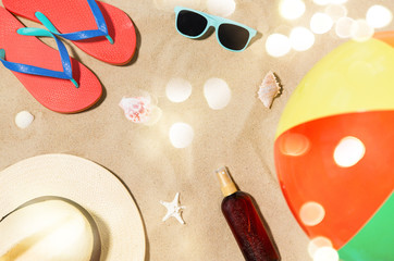 vacation and summer holidays concept - straw hat, flip flops, sunglasses, beach ball and sunscreen...