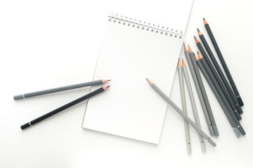 Top view, notebook with pencils on a white background.
