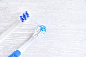 New and used toothbrushes with soft focus on blurred neutral background. Old unhygienic toothbrush and replacement new brush with selective focus. Two brushes for daily morning dental routine 