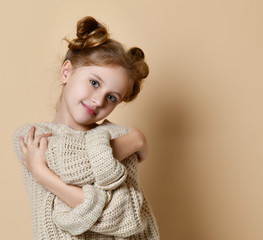Close Up portrait smiling girl holding hugging herself isolated nude wall background.