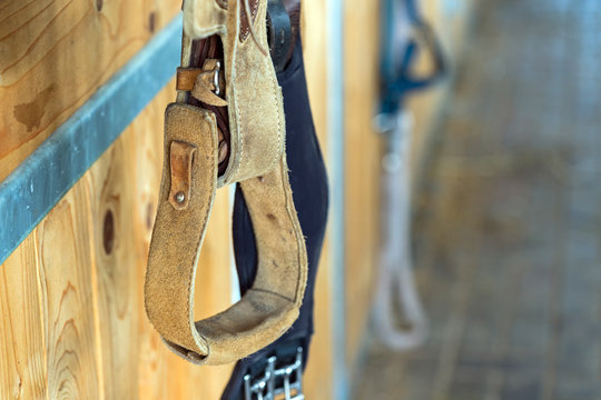closeup stirrup riding horse equipment hang on wooden fence