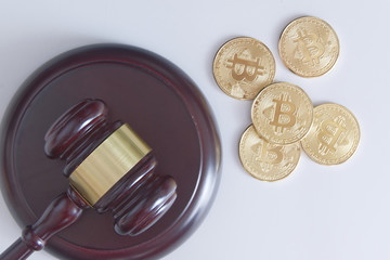 Judge mace next to some bitcoin currency coins from above. Top down view and legislation concept.