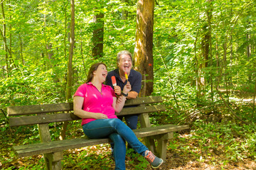 Couple Enjoying ice-cream while sitting on a bench of a public park