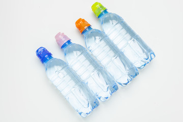 plastic water bottles with caps of different colour on the  table