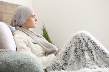 Woman after chemotherapy sitting on bed