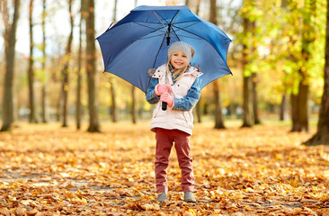 childhood, season and weather concept - happy little girl with umbrella at autumn park