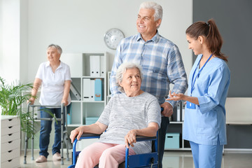 Fototapeta premium Elderly people with caregiver in nursing home