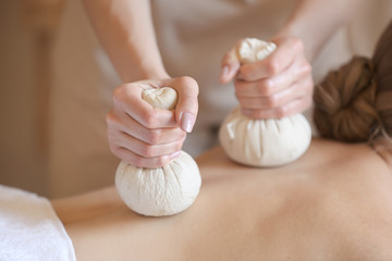 Beautiful young woman receiving massage in spa salon