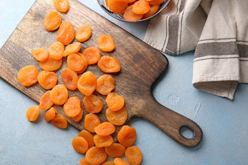 Board with dried apricots on table
