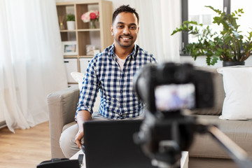 blogging, videoblog and people concept - indian male blogger with camera recording video at home