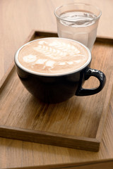 Hot latte with beautiful latte art on the wooden table