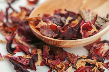 Dried tea heaped teaspoonful on white background, closeup