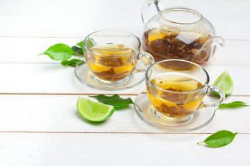 teapot and cups of tea on a white wooden background