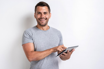 Happy man standing with ipad looking at the camera- Image