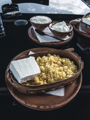Close up view of a typical macedonian meal. Polenta, with cheese and sour milk. National park Mavrovo , Macedonia.