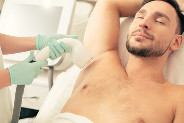 Obraz na płótnie Canvas Bearded man relaxing at the laser hair removal procedure