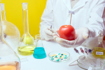 GMO Genetically modified food in lab concept. lab assistant Food safety laboratory procedure, analysing fruits from the market