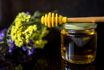gold honey in glass jar with dipper