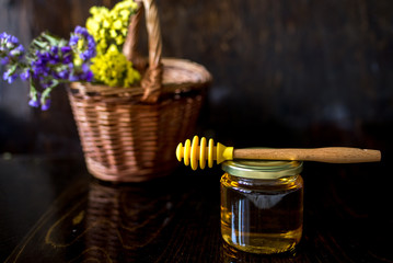 gold honey in glass jar with dipper