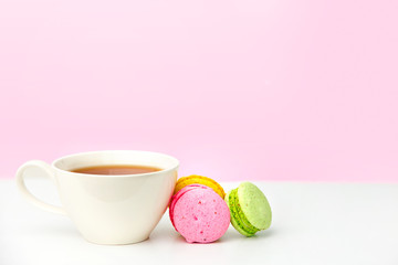  Mug on the table and colored biscuits on a white wooden table