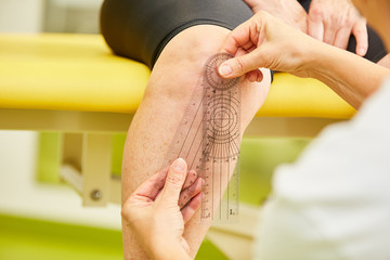 Physiotherapeut misst die Mobilität im Kniegelenk