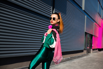 Back in time 90s 80s. Stylish girl in retro jacket and vintage cassette player listens to music,...