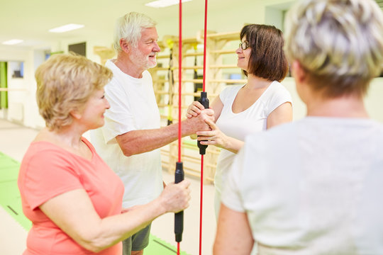 Fitnesstrainer und Senioren Gruppe mit Schwingstab