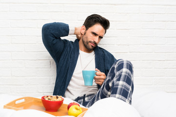 Man in bed with dressing gown and having breakfast