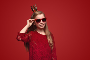 Smiling girl in crown and sunglasses