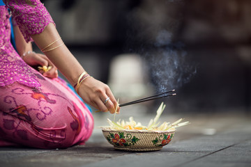 woman praying and  leaves gods offerings