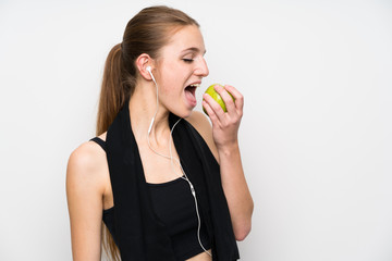 Young sport woman over isolated white background with an apple