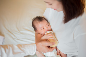 Obraz na płótnie Canvas Newborn baby girl is drinking milk by her mother