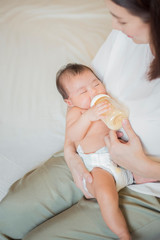 Newborn baby girl is drinking milk by  her mother