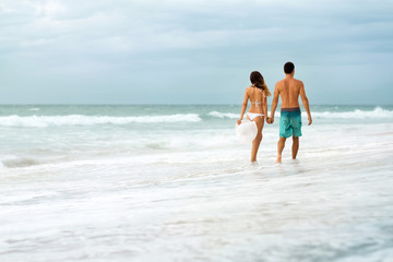 Young couple walking through waves